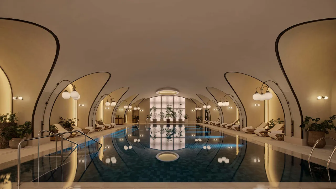 Large grand marble staircase illuminated by natural light from a skylight, leading down to the spa area.