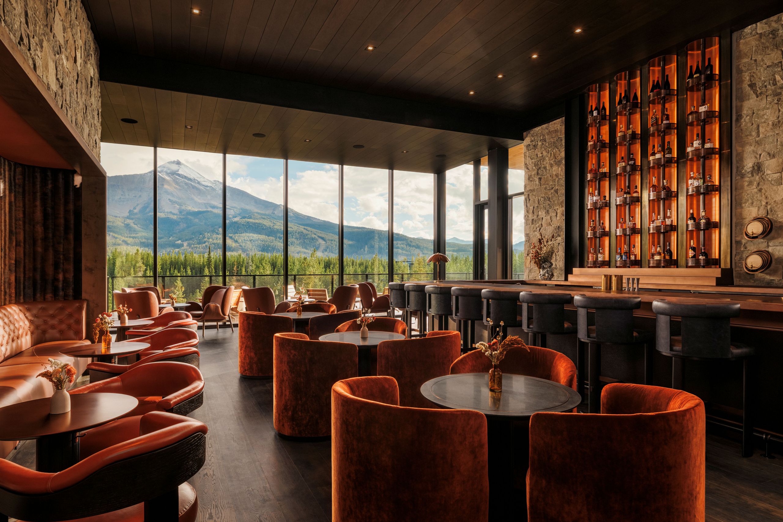 An exterior view of the luxurious Moonlight Basin resort at dusk, nestled within the mountainous landscape of Big Sky, Montana.