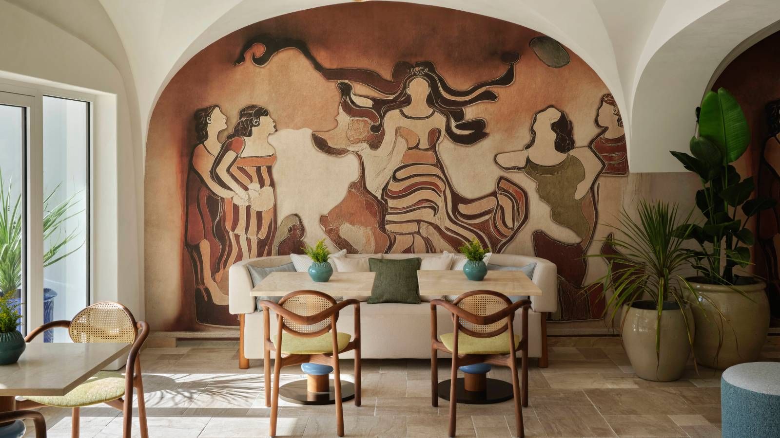 Vue extérieure de l'hôtel W Sardinia, montrant une architecture évoquant une grotte, se fondant dans le paysage côtier.