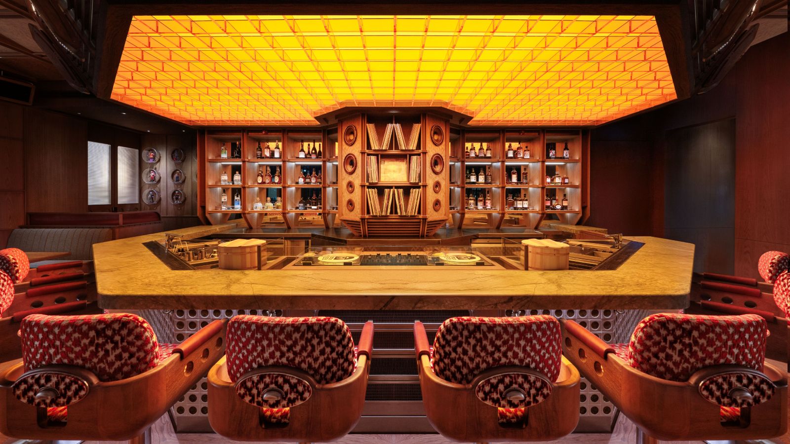 Interior view of Saikindō, showing a dimly lit, stylish Japanese hi-fi bar with a vinyl setup and a sleek robata counter.