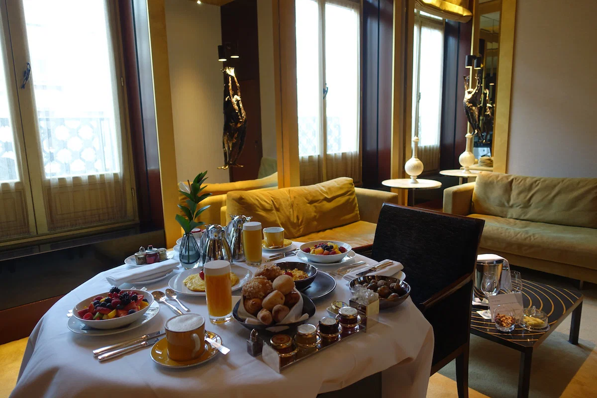Une suite d'hôtel luxueuse avec un ameublement élégant et une grande fenêtre, probablement à La Réserve Paris