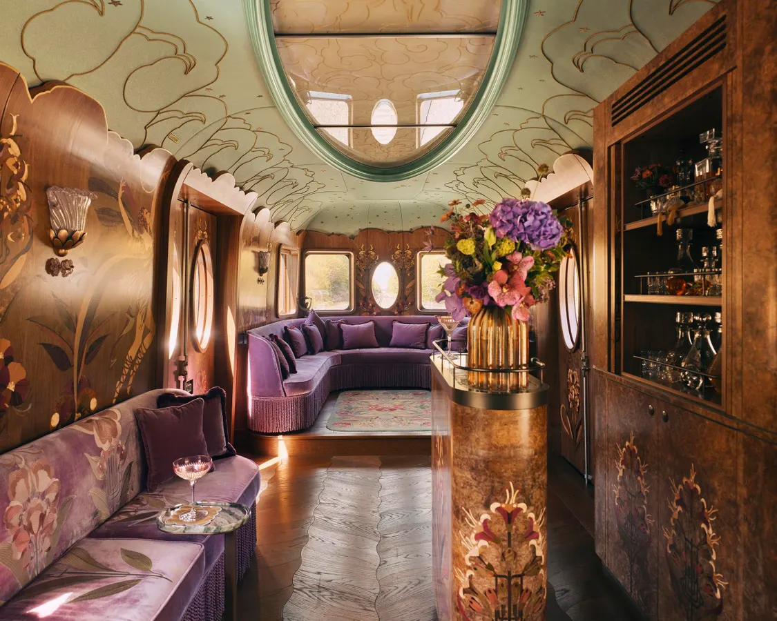 Luxurious interior of a vintage train carriage featuring elegant seating, art deco details, and a refined atmosphere.