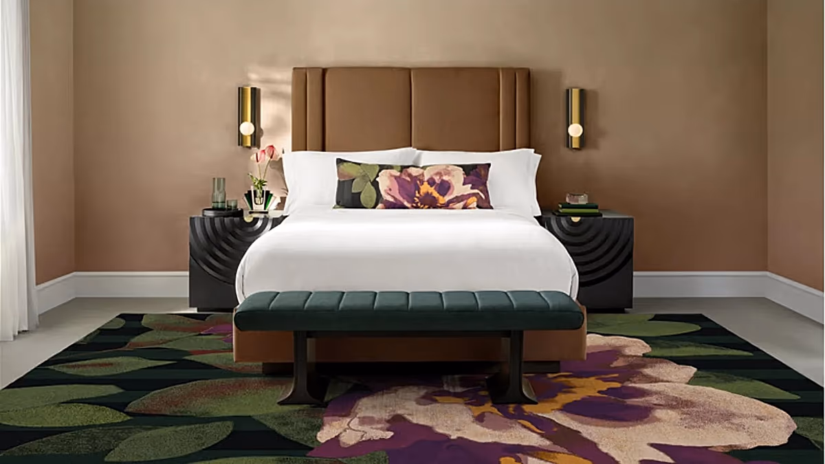 A stylishly furnished room with a large bed, elegant lighting, and modern decor, characteristic of a luxury hotel suite