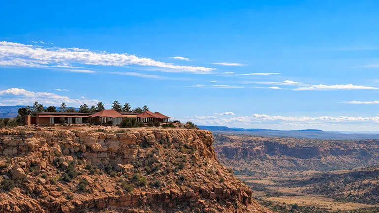 A luxurious tented pavilion with panoramic views of the Utah landscape, possibly at sunrise or sunset