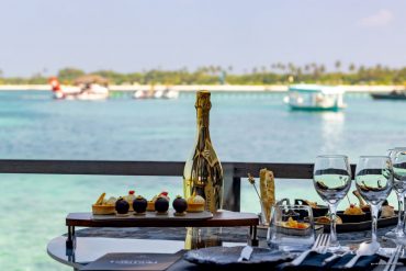 A building on the Champs-Élysées, illuminated at night, wrapped in a giant Louis Vuitton trunk facade.