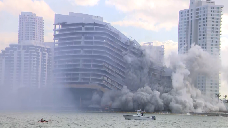 Large luxury hotel building collapsing in a cloud of dust during a controlled implosion