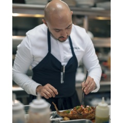 Luxurious dining setting at NUNA, Four Seasons Hotel Miami, with a focus on a beautifully plated Nikkei dish.