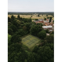 A refined afternoon tea setting with tennis-themed pastries and fine china, likely in a luxurious hotel lounge.