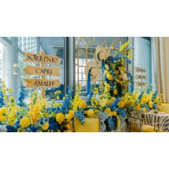Afternoon tea spread with Italian pastries and savories, set against a Mediterranean-inspired backdrop