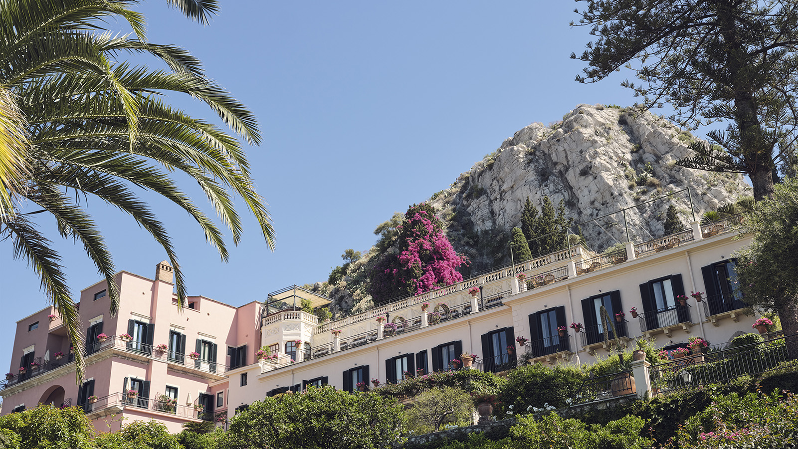 Exterior view of the Dior Spa at Grand Hotel Timeo, with lush gardens and a classic architectural style.