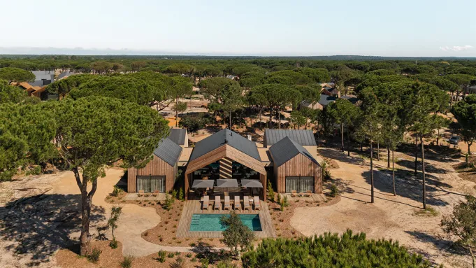 Exterior view of a Sublime Sand villa with a private pool and natural landscaping under a clear sky