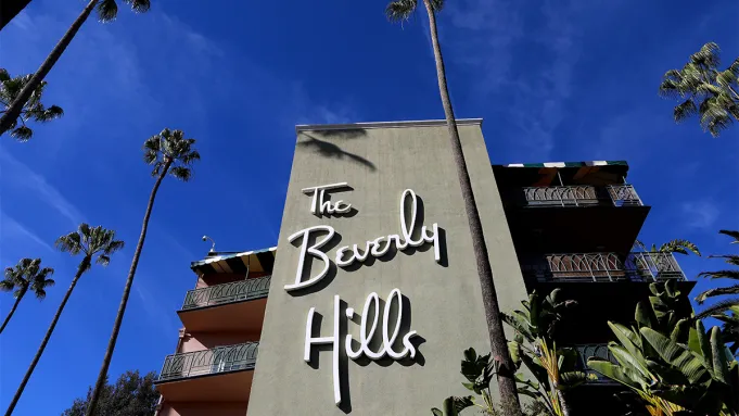 L'extérieur du Beverly Hills Hotel avec sa façade rose emblématique et ses auvents à rayures vertes et blanches