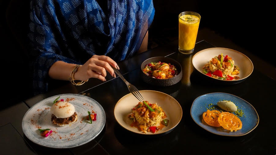 A vibrant Indian street food dish with a glass of beverage, likely Seabass Fritters with Riesling.