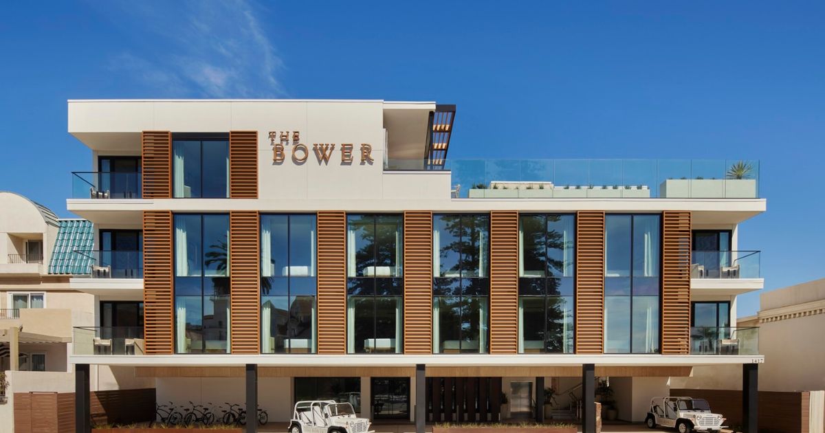 Exterior view of The Bower Coronado, a modern low-rise hotel with a rooftop terrace overlooking the ocean