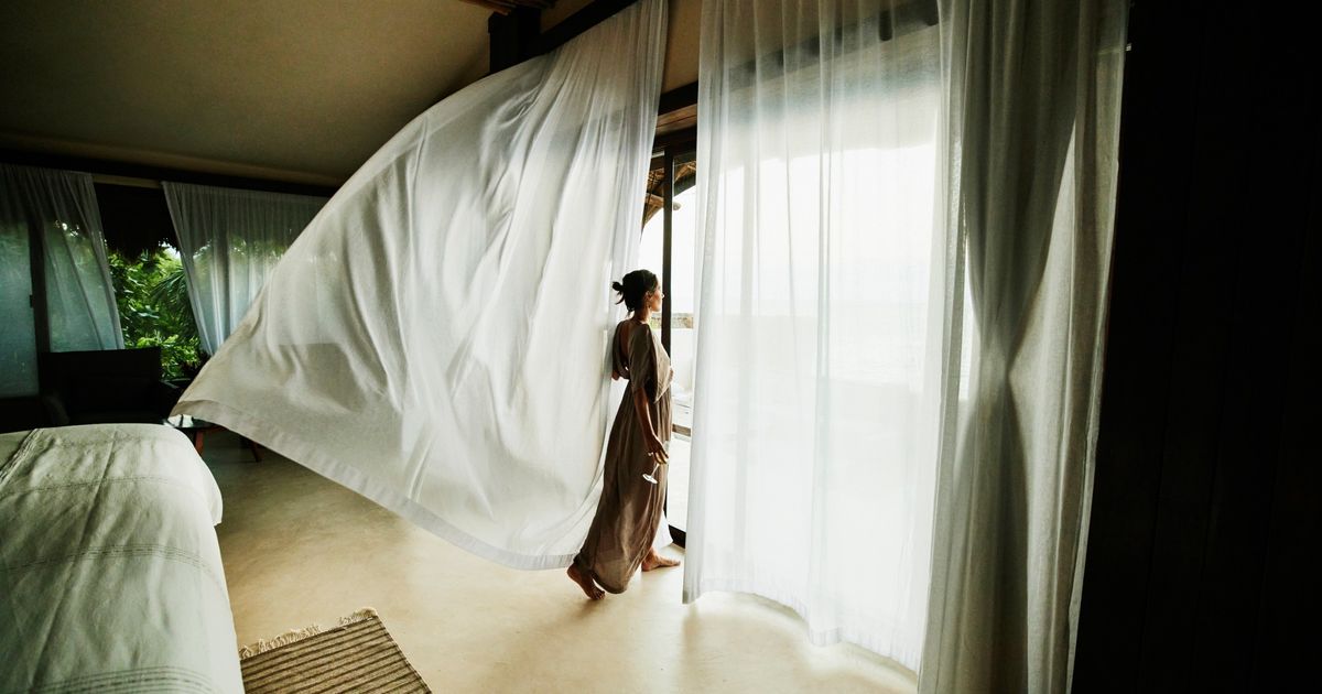 A modern luxury hotel with light-filled rooms and a view of water villas.