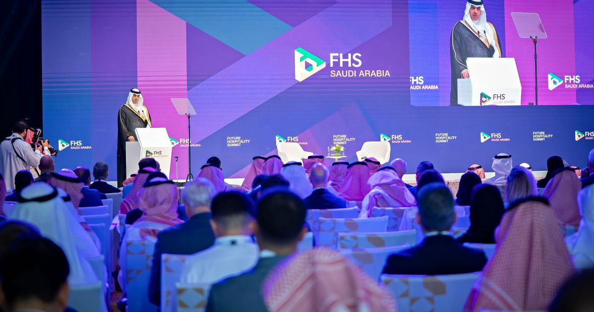 A bustling conference hall with attendees and speakers on stage, possibly at the Future Hospitality Summit in Riyadh.