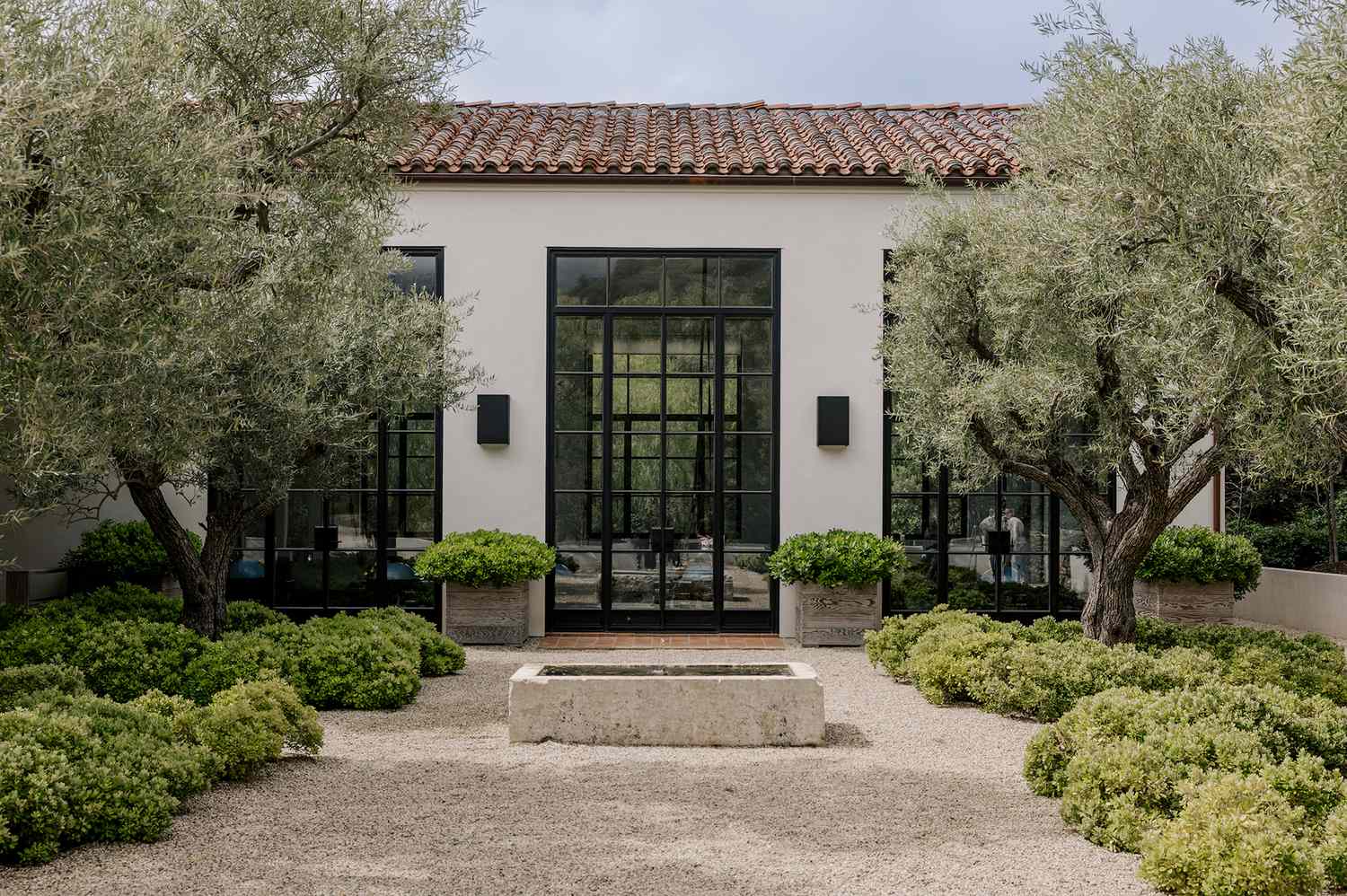 Un cottage privé moderne et serein à The Ranch Malibu, entouré d'une végétation luxuriante, évoquant une retraite de bien-être tranquille.