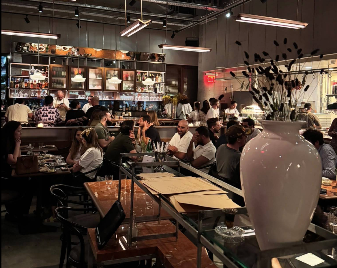 A modern, upscale Mediterranean restaurant interior with stylish lighting and table settings.
